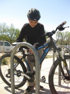 Kristopher Cubias practices locking his bike on the school bike racks.